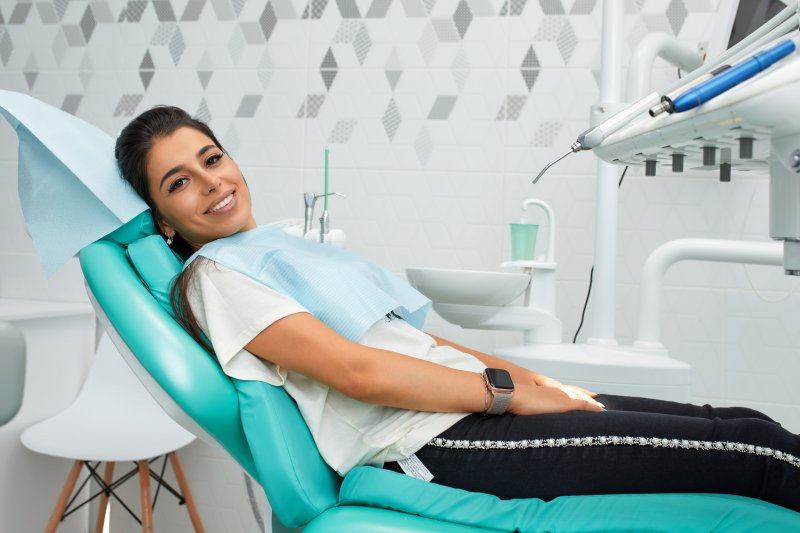 a young woman lying back in a dentist’s chair preparing for her checkup and cleaning