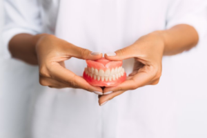 Dentist carefully holding a full set of dentures